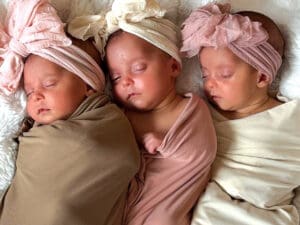 Three babies sleeping next to each other with head wraps